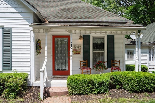 doorway to property with roof with shingles and covered porch