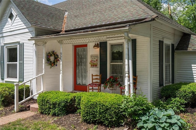 view of front facade with roof with shingles and covered porch