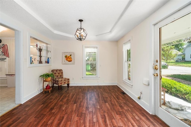 sitting room with wood finished floors, plenty of natural light, and a chandelier