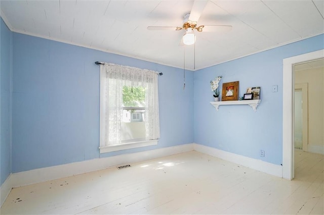 spare room with wood finished floors, baseboards, and ceiling fan