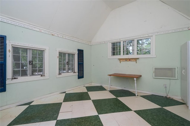 unfurnished room with lofted ceiling, tile patterned floors, and a wall mounted air conditioner