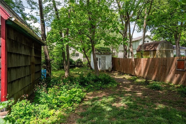 fenced yard with a shed and an outbuilding