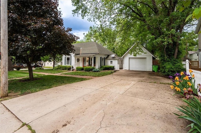view of front of property featuring an outdoor structure, driveway, and a detached garage