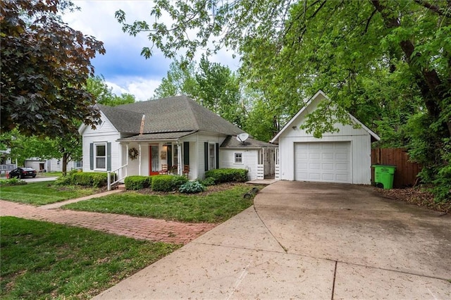 view of front facade with driveway, a garage, covered porch, and an outbuilding