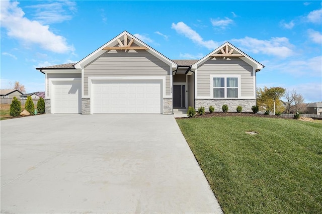 craftsman house with a front yard, driveway, stone siding, and a garage