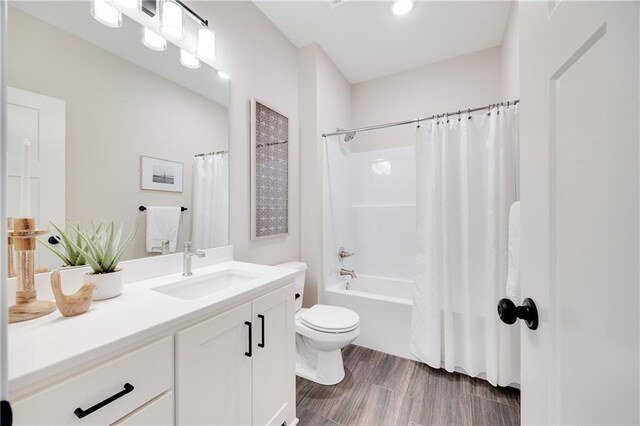 bathroom featuring vanity, shower / tub combo, wood finished floors, and toilet