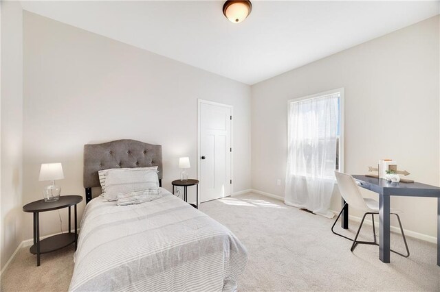 bedroom with baseboards and light carpet