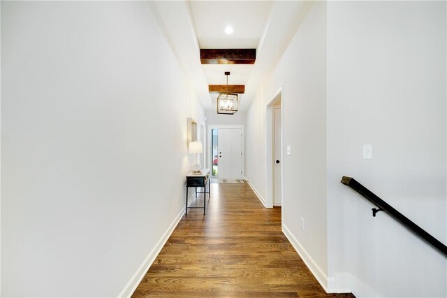 hallway featuring baseboards, an upstairs landing, and wood finished floors