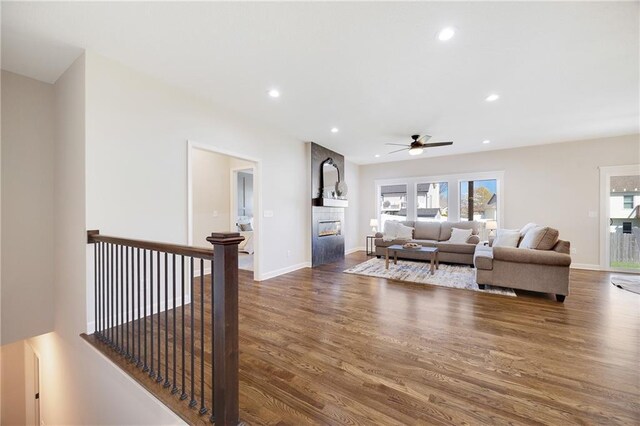 living room featuring a fireplace, a ceiling fan, recessed lighting, and wood finished floors