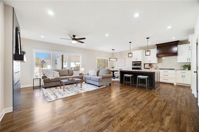 living area featuring recessed lighting, baseboards, a ceiling fan, and dark wood finished floors