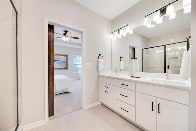 ensuite bathroom with a sink, double vanity, a ceiling fan, baseboards, and a shower stall