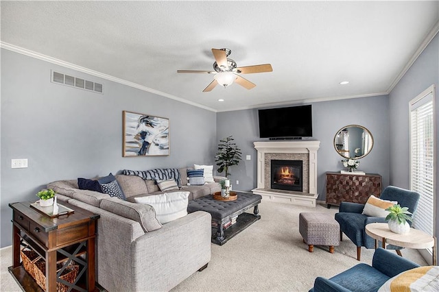 carpeted living room with a ceiling fan, crown molding, a lit fireplace, and recessed lighting