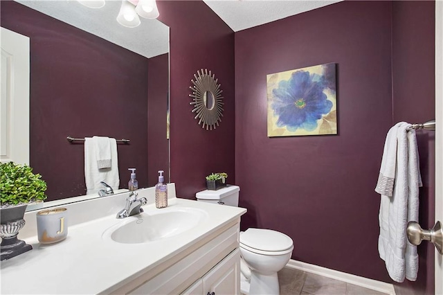 half bathroom with toilet, vanity, and tile patterned flooring