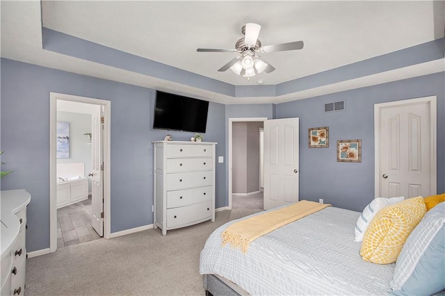 bedroom featuring light carpet, baseboards, a raised ceiling, and ceiling fan