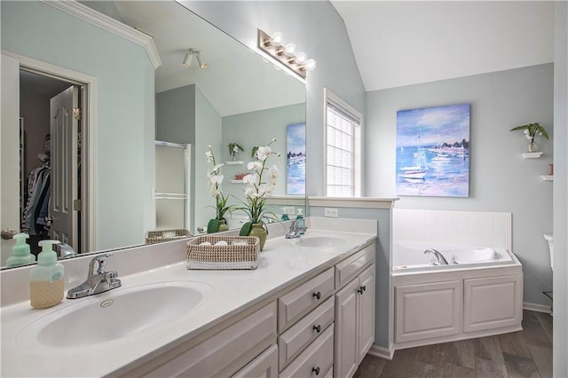 bathroom with vaulted ceiling, a garden tub, double vanity, a stall shower, and wood finished floors