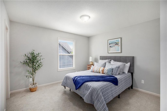 bedroom featuring carpet, baseboards, and a textured ceiling