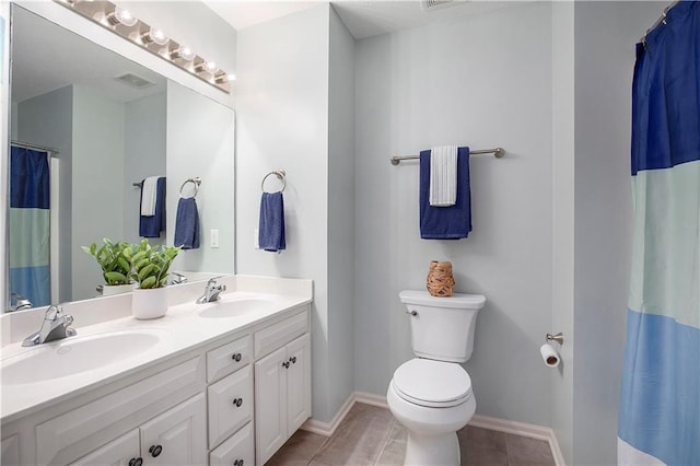 full bath with toilet, double vanity, baseboards, and tile patterned flooring