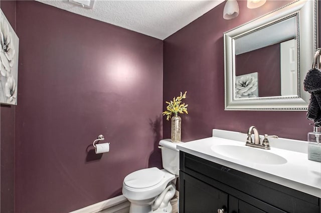 bathroom with a textured ceiling, toilet, and vanity