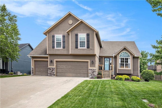 view of front of property with a front yard, driveway, a garage, and stone siding