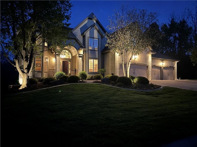 7419 Constance St, Shawnee, KS 66216 - view of front of house with stucco siding, a yard, driveway, and a garage
