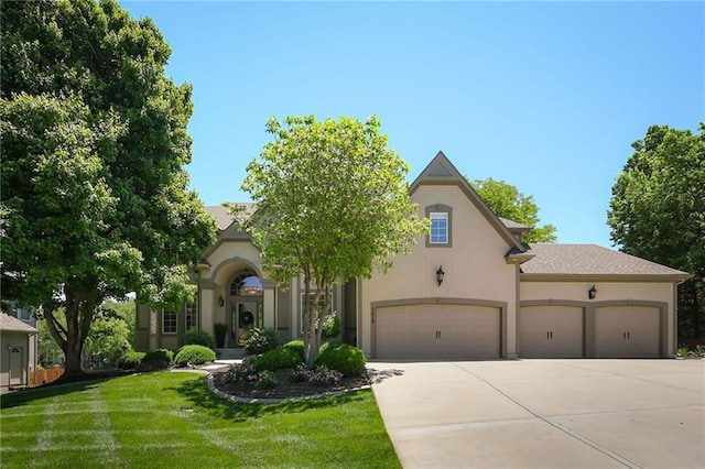 7419 Constance St, Shawnee, KS 66216 - view of front of house featuring stucco siding, concrete driveway, a front yard, and an attached garage