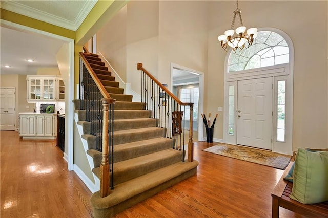 7419 Constance St, Shawnee, KS 66216 - foyer entrance featuring stairway, a chandelier, light wood-type flooring, ornamental molding, and baseboards