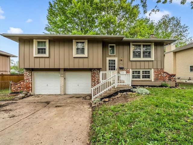 bi-level home featuring board and batten siding, a garage, brick siding, fence, and concrete driveway