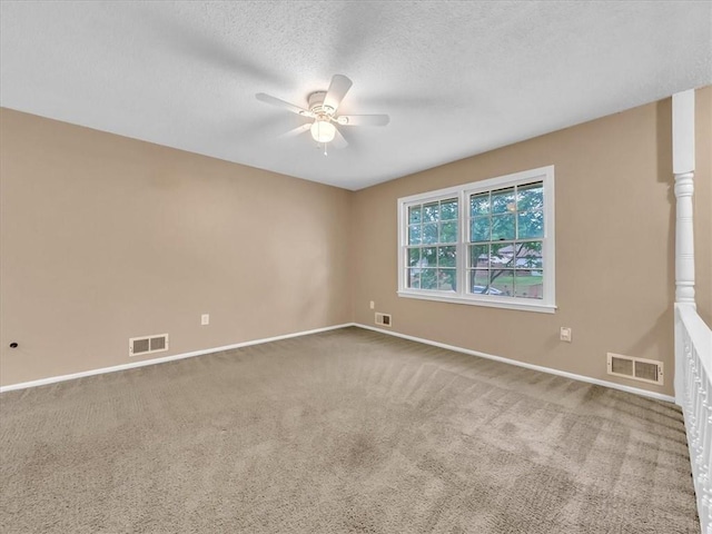 unfurnished room with visible vents, a ceiling fan, and carpet
