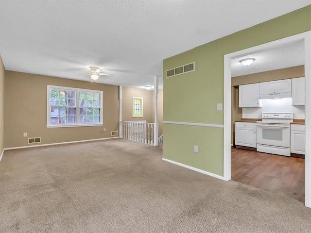 empty room featuring visible vents, carpet flooring, baseboards, and ceiling fan