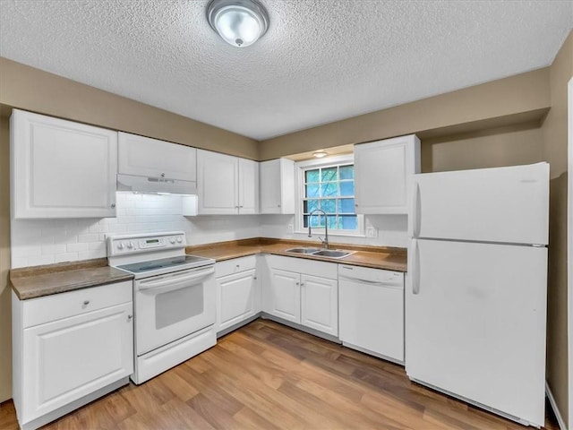 kitchen with a sink, under cabinet range hood, white cabinets, and white appliances