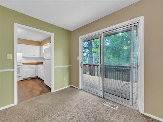 doorway to outside featuring visible vents, baseboards, and dark carpet