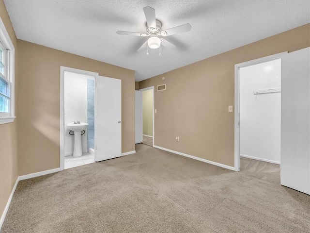 unfurnished bedroom featuring baseboards, carpet, a spacious closet, and visible vents