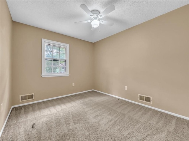empty room featuring carpet, a textured ceiling, and visible vents