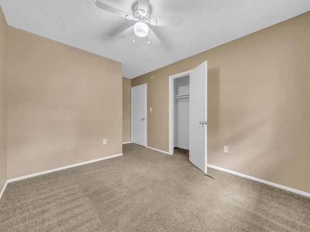 unfurnished bedroom featuring carpet floors, a textured ceiling, a ceiling fan, baseboards, and a closet