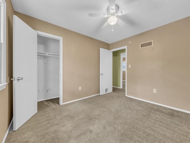 unfurnished bedroom with ceiling fan, visible vents, baseboards, a closet, and carpet