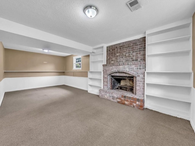 unfurnished living room featuring carpet, a brick fireplace, a textured ceiling, and visible vents