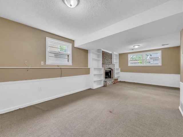 unfurnished living room featuring a textured ceiling, built in features, baseboards, and carpet