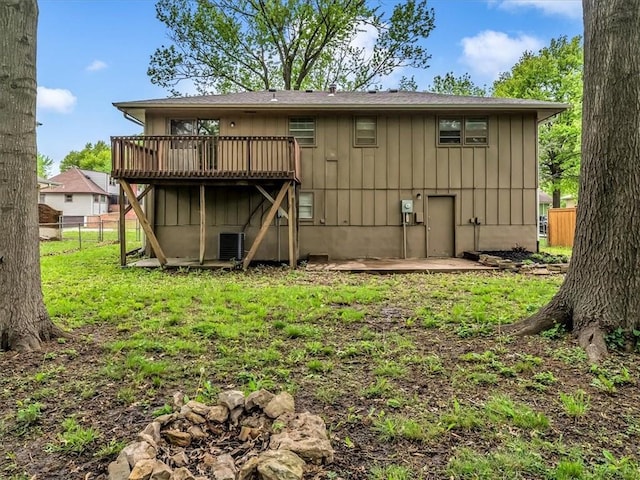 rear view of property featuring a yard, fence, a wooden deck, and central AC unit