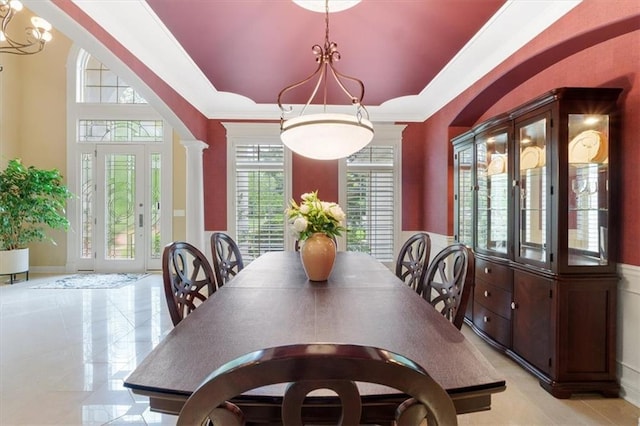 dining room with a chandelier, ornamental molding, and decorative columns