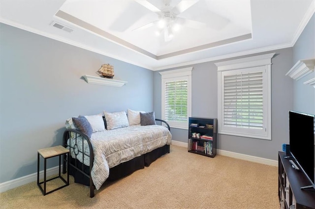 bedroom featuring a raised ceiling, carpet flooring, ornamental molding, baseboards, and a ceiling fan