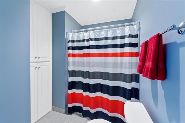 full bathroom featuring a shower with shower curtain, crown molding, and tile patterned floors