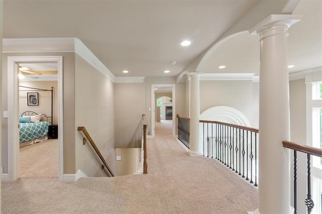corridor featuring an upstairs landing, carpet floors, decorative columns, recessed lighting, and arched walkways