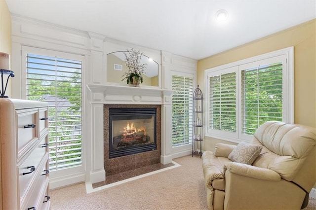 sitting room with carpet floors, healthy amount of natural light, and a premium fireplace
