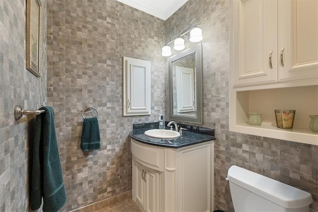 bathroom featuring tile walls, ornamental molding, vanity, toilet, and tile patterned floors