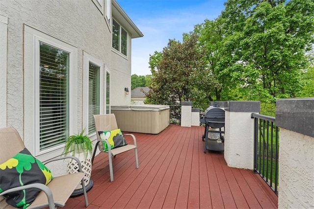 deck featuring a hot tub and area for grilling