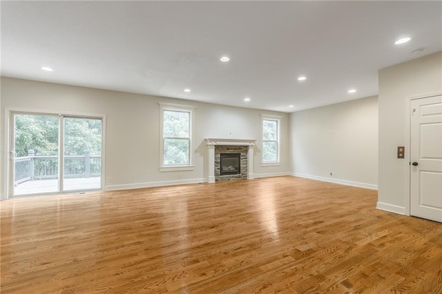 875 Clearview Dr, Lansing, KS 66043 - unfurnished living room with light wood-style flooring, a glass covered fireplace, and recessed lighting