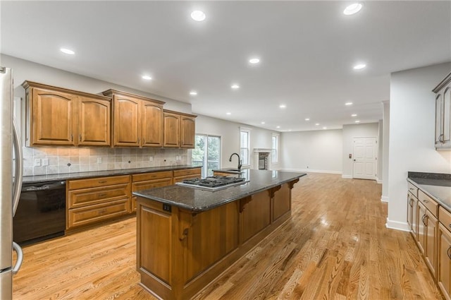 875 Clearview Dr, Lansing, KS 66043 - kitchen featuring stainless steel appliances, an island with sink, brown cabinetry, backsplash, and recessed lighting