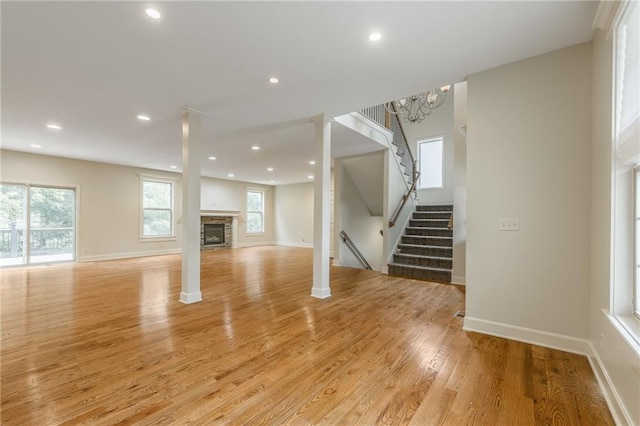 875 Clearview Dr, Lansing, KS 66043 - unfurnished living room featuring stairway, light wood-style flooring, a fireplace, and recessed lighting