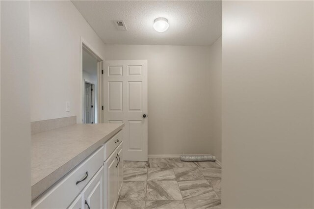875 Clearview Dr, Lansing, KS 66043 - bathroom featuring a textured ceiling, marble look tile flooring, and vanity