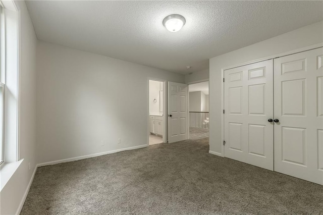 875 Clearview Dr, Lansing, KS 66043 - unfurnished bedroom featuring carpet flooring, a textured ceiling, a closet, and connected bathroom